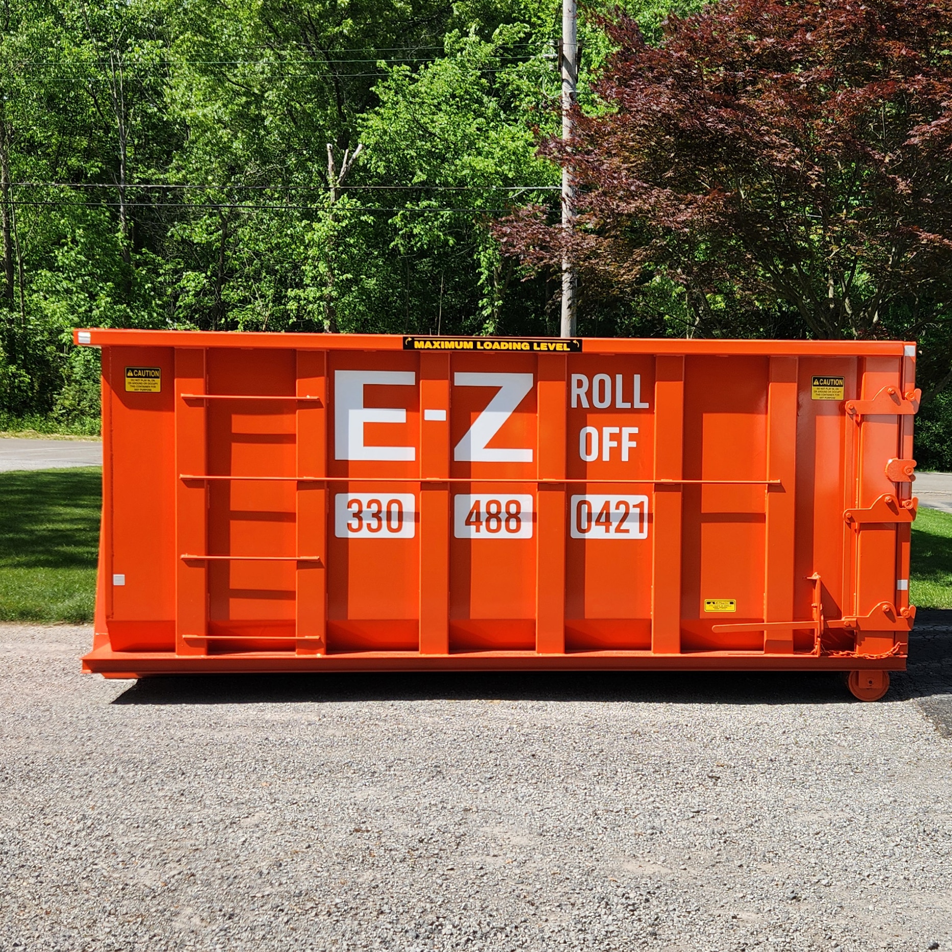 Large orange EZ Roll Off Dumpster on a customer's driveway.